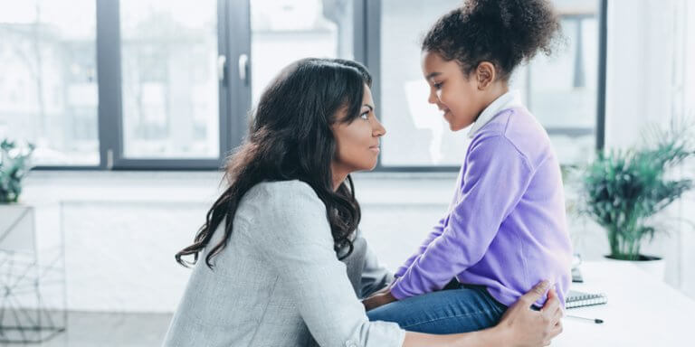 disciplina positiva: mulher conversando com a criança que está sentada em cima de uma pesa