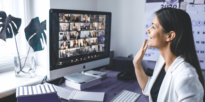 Mulher promovendo gestão de equipes com colaboradores em videochamada em casa