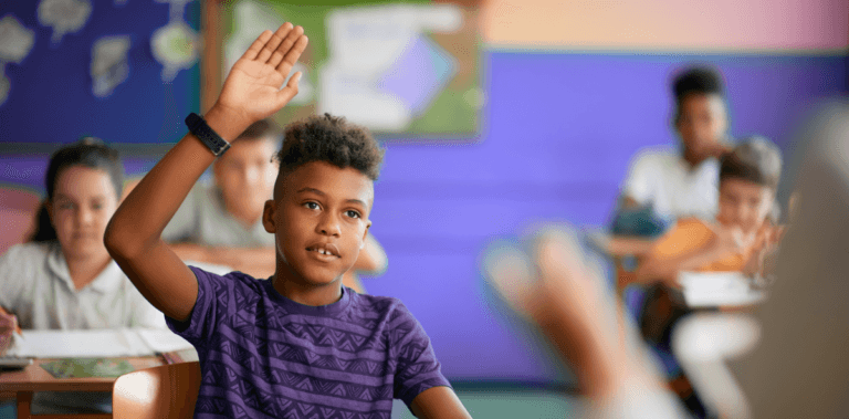 Jovem garoto estudante levantando a mão na sala de aula, representando o perfil de um aluno protagonista